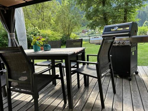 una parrilla, una mesa y sillas en una terraza en Lillibets Paradies am See, en Erlach