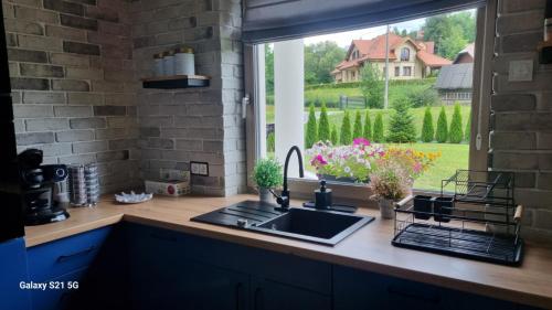 a kitchen with a sink and a window at ZuMiLu House in Zagórz