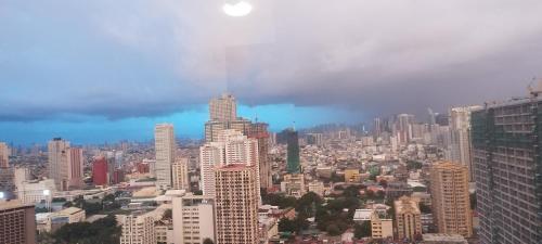 a city skyline with skyscrapers on a cloudy day at The Radiance Manila Bay Studio 2 in Manila