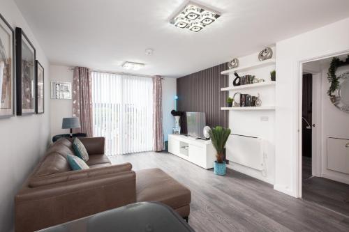a living room with a couch and a television at The East Retreat in Manchester