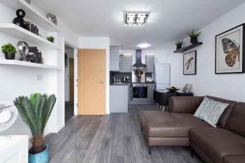 a living room with a couch and a kitchen at The East Retreat in Manchester