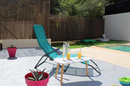 une chaise et une table à côté de la piscine dans l'établissement Charmante Villa individuelle Niçoise avec piscine privée proche Monaco, à Peille