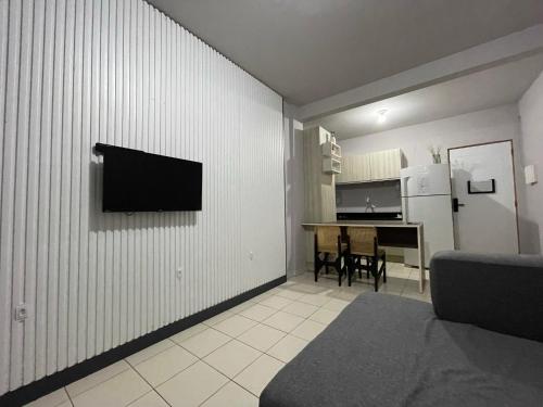a living room with a television on a wall at Link Araranguá in Araranguá