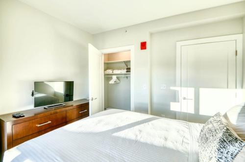 a white bedroom with a bed and a mirror at Gorgeous Apt Near Restaurants in Quincy