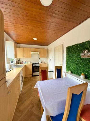 a kitchen with a table and a green wall at Cosy Inn near Luton Station, Mall and Luton Airport 10 Min in Luton