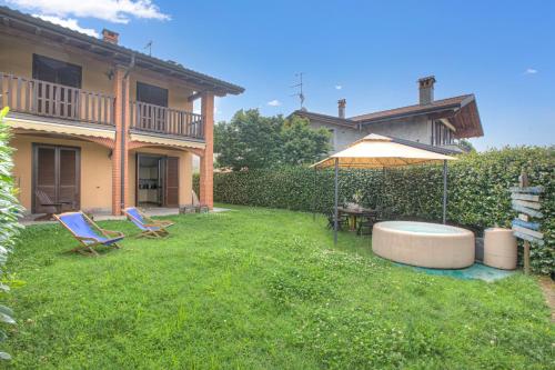 a yard with two chairs and an umbrella at La Luna nel Lago Lake View Garden - Happy Rentals in Ispra