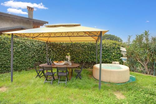 a table and chairs under a yellow umbrella with a tub at La Luna nel Lago Lake View Garden - Happy Rentals in Ispra