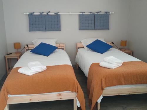 deux lits dans une chambre avec des serviettes dessus dans l'établissement Les Magnolias, à Les Sables-dʼOlonne