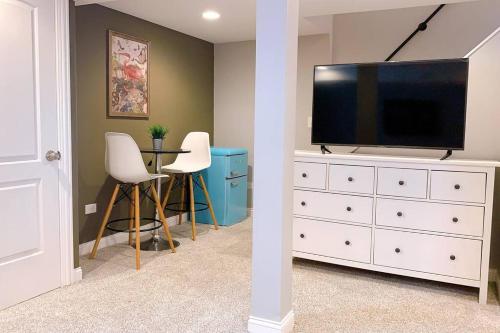 a living room with a television on a white dresser at BOUTIQUE GARDEN HOUSE CHICAGO 3-STORY sleeps 12 in Chicago