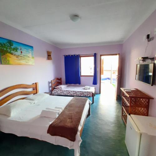 a bedroom with two beds in a room with purple walls at Villa Tropicale in Salvador
