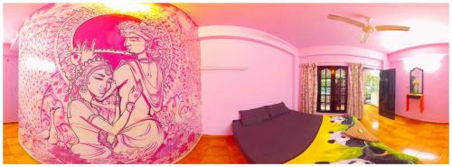 a room with a large painting on the wall at Santa Maria Hostel Kovalam in Kovalam