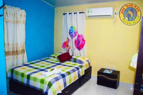 a small bedroom with a bed with a plaid blanket at ann dor place 1 in San Andrés