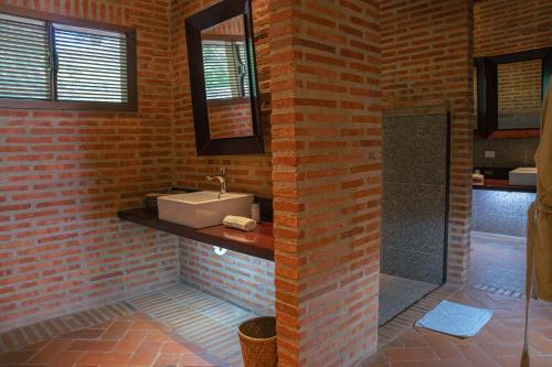 a brick bathroom with a sink and a shower at Castillete Hotel & Beach Club in Tierra Bomba