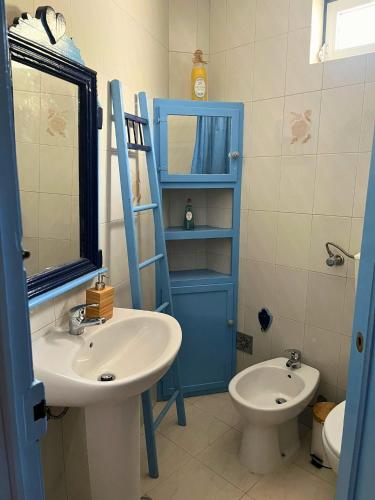 a bathroom with a sink and a toilet and a blue door at Casa do Viajante in Cabeção