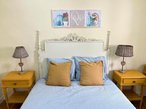 a bedroom with a bed with blue sheets and two lamps at Casa do Viajante in Cabeção