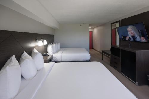 a hotel room with a bed and a flat screen tv at B&B Hotel Miami Airport in Miami