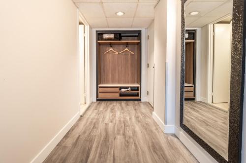 a hallway with a mirror and a closet at Atrium Hotel Vancouver in Vancouver