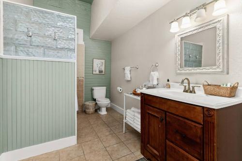 a bathroom with a sink and a toilet and a mirror at #14 The Country Suite at Garrison in Gruene in New Braunfels