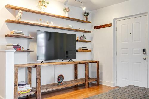 a flat screen tv on a wooden stand in a living room at Peaceful & spacious family home near Carytown fully fenced in Richmond
