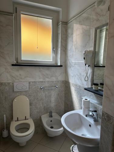 a bathroom with a toilet and a sink and a mirror at Camere Margot in Monterosso al Mare