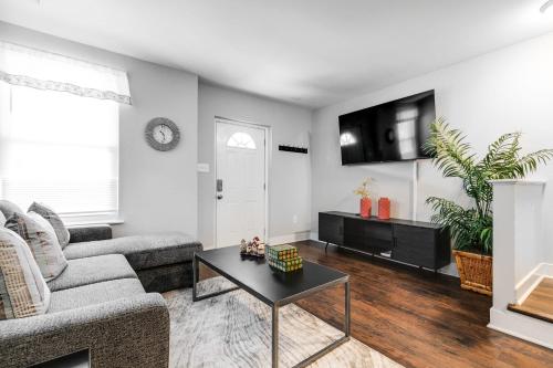 un soggiorno con un divano e un tavolo di Cozy spacious family home near Carytown fully fenced a Richmond