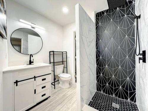 a bathroom with a toilet and a shower with a mirror at Family-friendly 2br Wi-fi Pets Near Disney in Orlando