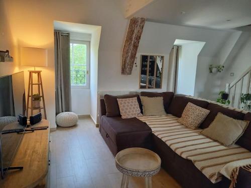 un salon avec un canapé marron et une table dans l'établissement Les Vues de Lily - Dijon, à Dijon