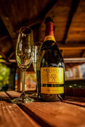 a bottle of wine and a glass on a table at Glamping nad Sanem in Krzemienna