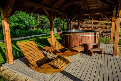 two chairs and a wooden barrel under a gazebo at Glamping nad Sanem in Krzemienna