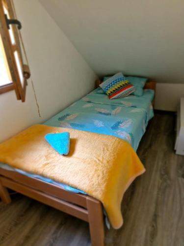 a small bed in a small room with a table at Drinska bajka in Mali Zvornik