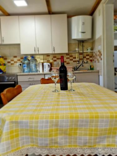 a bottle of wine sitting on a table with two glasses at Drinska bajka in Mali Zvornik