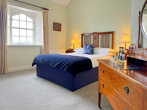 a bedroom with a bed and a dresser and a mirror at Stella Maris Shore House in Ballycastle