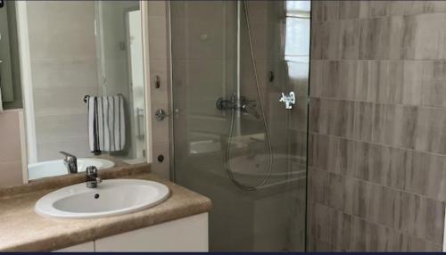 une salle de bain avec un lavabo et une douche dans l'établissement Le Mas Cayrel, à Uzès