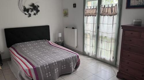 - une chambre avec un lit, une commode et des fenêtres dans l'établissement Le Mas Cayrel, à Uzès