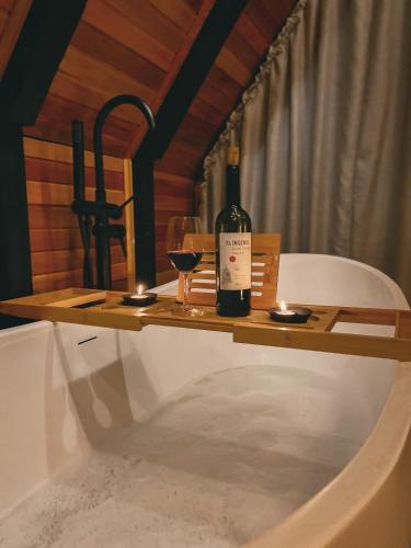 a wooden table with a bottle of wine and glasses at Cabana The Wild Urubici in Urubici