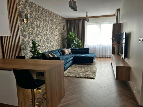 a living room with a blue couch and a table at Apartamenty Termal Water Długa 30 in Uniejow