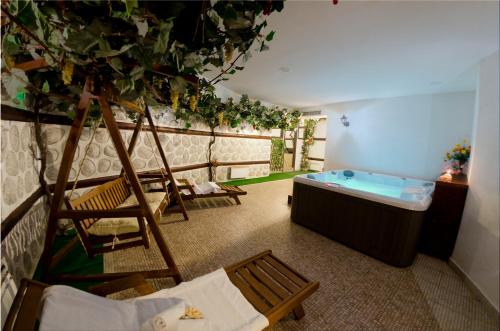 a room with a bath tub and a tree at Mountain Romance Family Hotel in Bansko