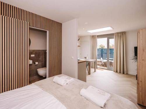 a bedroom with a large bed and a bathroom at Ceebee - Free parking in Zandvoort