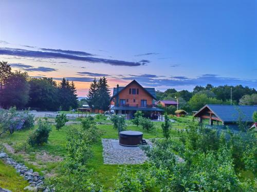 a house in the middle of a field with a building at Pensiunea Pastravaria Vistisoara in Vistisoara