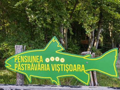 a sign for a park with a dinosaur on it at Pensiunea Pastravaria Vistisoara in Vistisoara