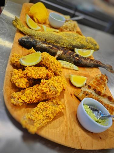 a wooden cutting board with different types of food on it at Pensiunea Pastravaria Vistisoara in Vistisoara
