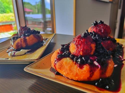 two plates of food on a table with a dessert at Pensiunea Pastravaria Vistisoara in Vistisoara