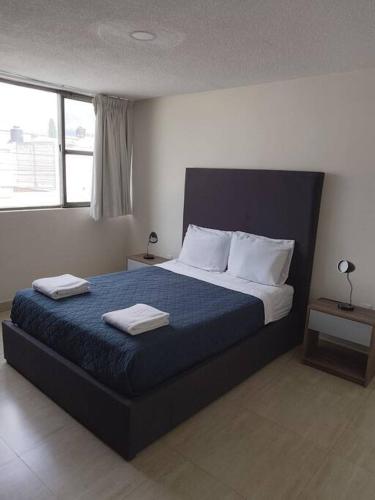 a bedroom with a bed with two towels on it at Hermosa casa grande en San Manuel in El Gallinero