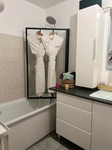 une salle de bain avec un miroir, un lavabo et une baignoire dans l'établissement Home Disney Torcy, à Torcy