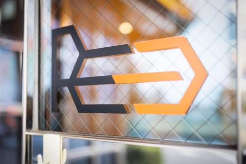 an orange and black sign on a glass door at Reco Hotel Mikuni in Toyonaka