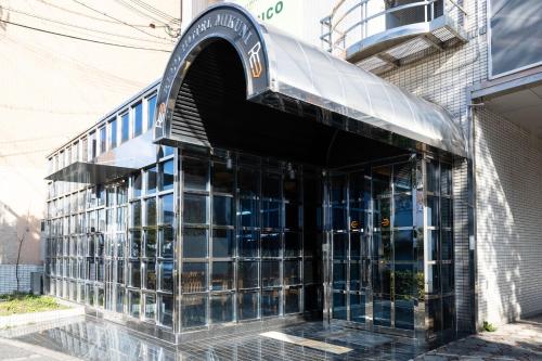 an entrance to a building with a glass facade at Reco Hotel Mikuni in Toyonaka