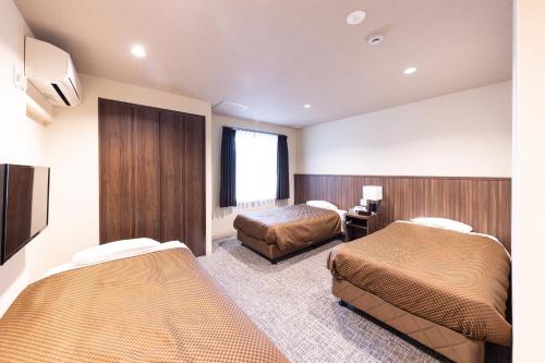 Postel nebo postele na pokoji v ubytování Reco Hotel Mikuni