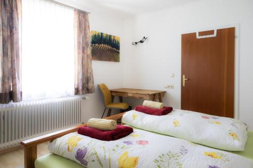 two beds in a room with a table and a window at Appartement Schareckblick in Bad Gastein