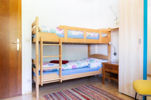 a bedroom with two bunk beds and a desk at Appartement Schareckblick in Bad Gastein