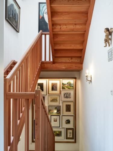 a staircase with framed pictures on the wall at Romantik Hotel Jagdhof in Caldaro
